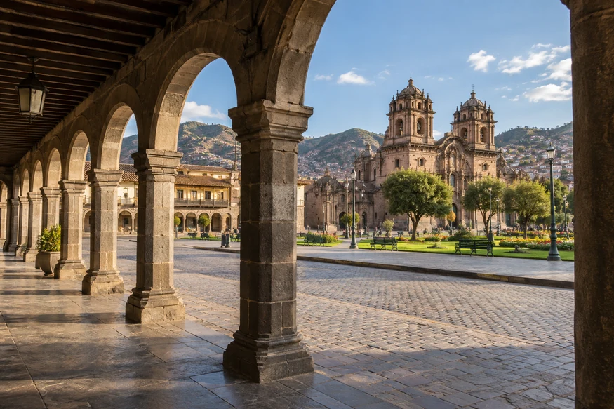 Colonial arcade framing a view of Cusco Plaza de Armas and cathedral