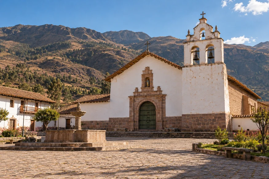San Juan Bautista Church in Huaro with its colonial bell gable and Andean mountains Cusco Peru